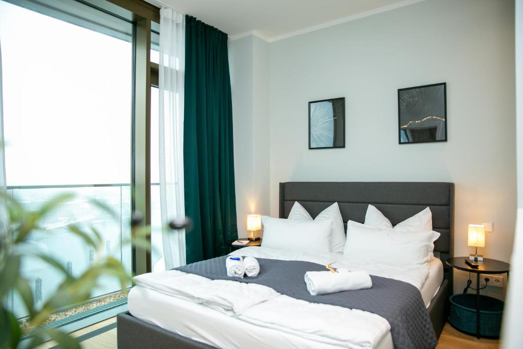 1 dormitorio con 1 cama con 2 toallas en CABANA - TheView - 10th Floor - Terrasse - Waterfront - Hafenviertel, en Oldenburg