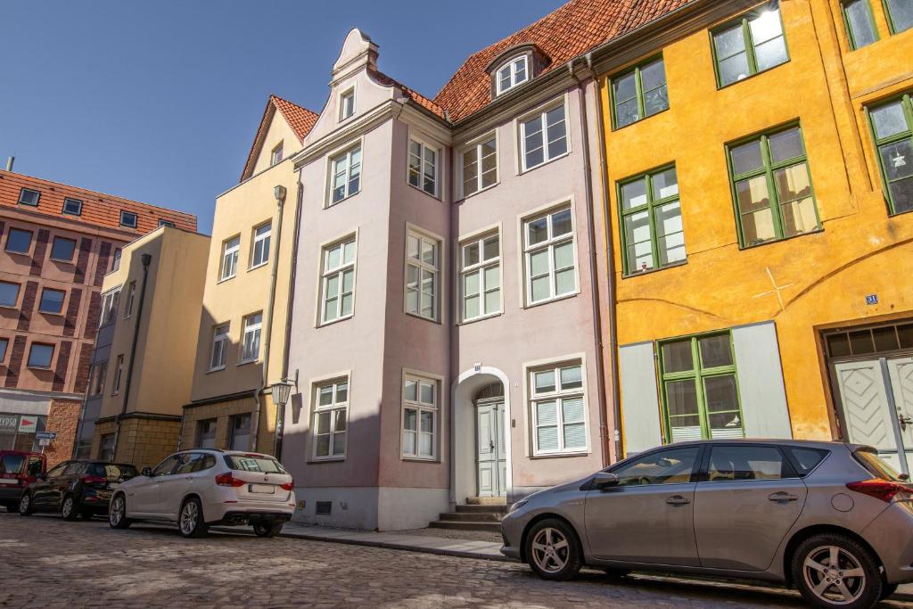 two cars parked in front of a building at Ferienwohnungen in der Altstadt Stralsund in Stralsund
