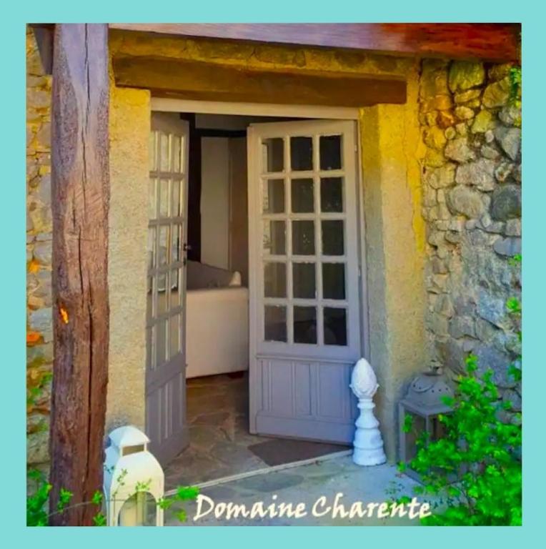une porte d'entrée d'une maison avec un canapé derrière dans l'établissement Domaine Charente Glamping Familyroom Le Jardin with external toilet & shower house & outdoor kitchen, à Mazières