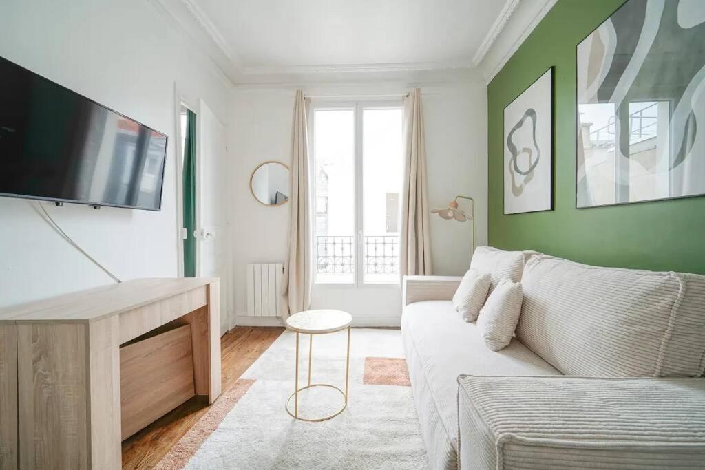 ein Wohnzimmer mit einem Sofa und einem Flachbild-TV in der Unterkunft Apartment proche Vaugirard - Sauge - III in Paris