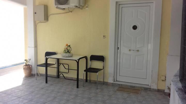 Ανεξάρτητο διαμέρισμα κοντά στο κέντρο της πάτρας في باترا: غرفة بطاولة وكراسي وباب أبيض