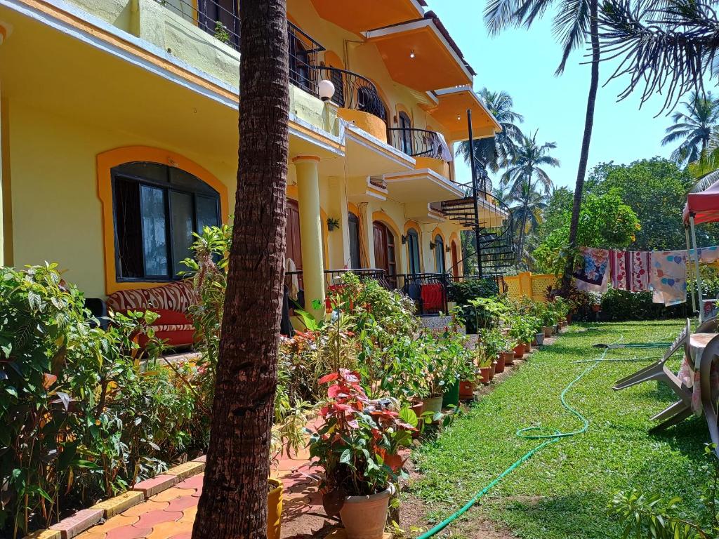 a yellow building with a hose in front of a yard at FLOBESTIAN BEACH VILLA CANDOLIM BEACH in Aguada