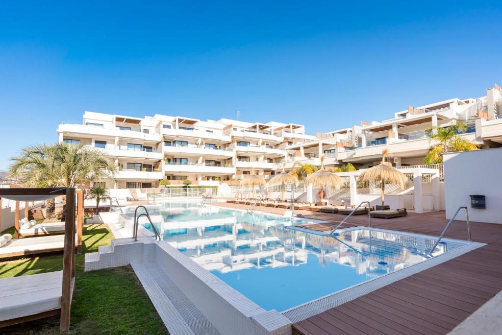 a hotel with a swimming pool in front of a building at Stunning Apt in Mijas by Costarentals - Ref 235 in Mijas Costa