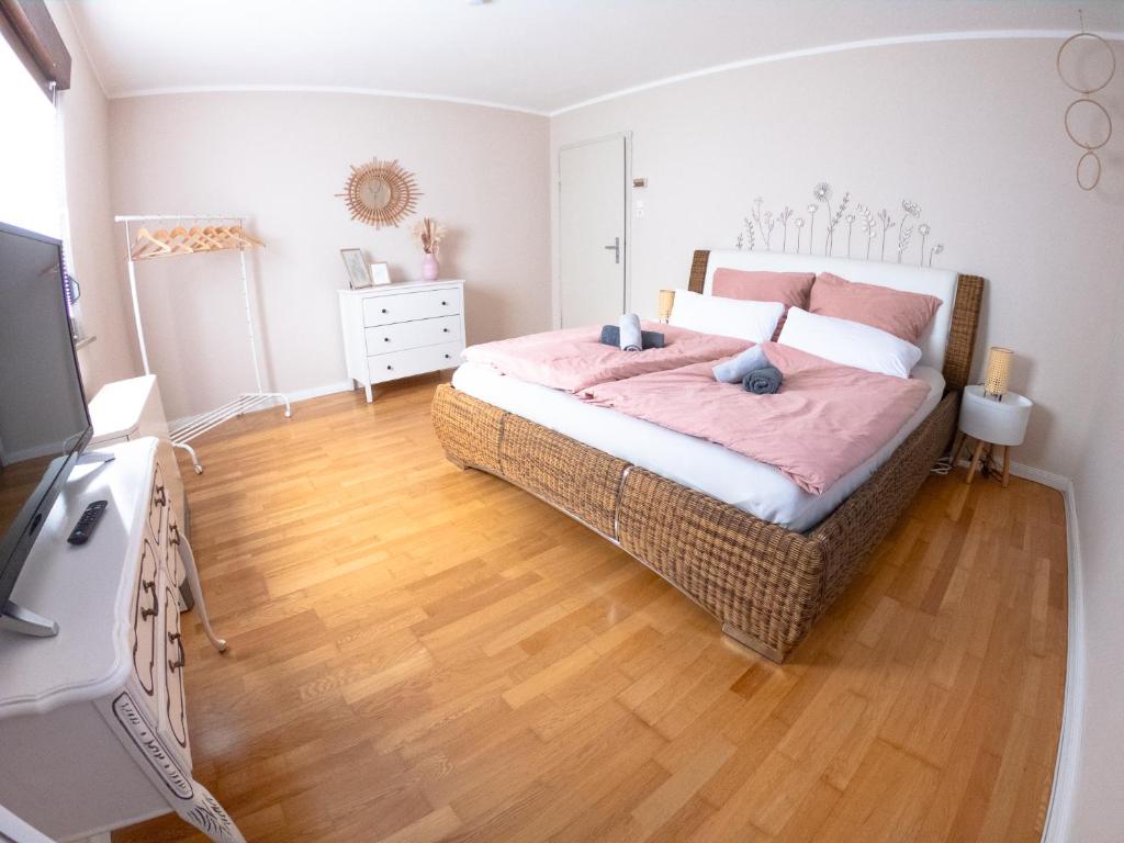a bedroom with a large bed and a wooden floor at HappyBNB Apartment mit sonniger Terrasse in Löchgau