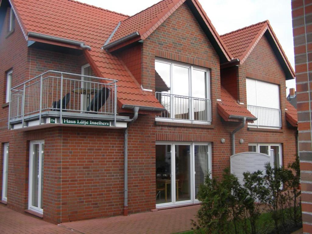 a red brick house with a balcony on it at Strandkorb in Borkum