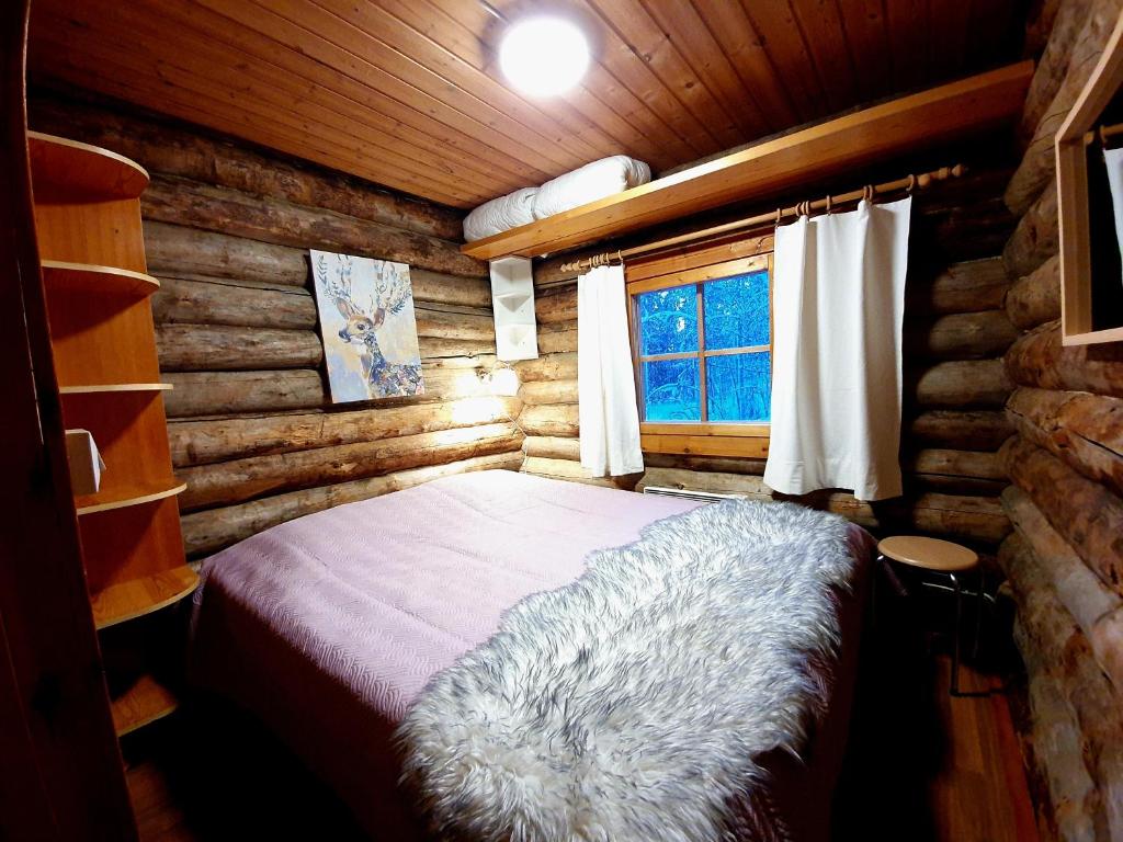1 dormitorio con 1 cama en una cabaña de madera en Keloharju 18, en Syöte