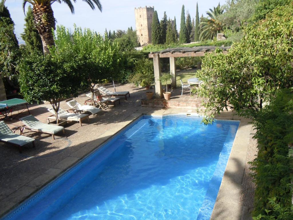 una gran piscina azul con sillas y árboles en Palacio Chaves Hotel, en Trujillo