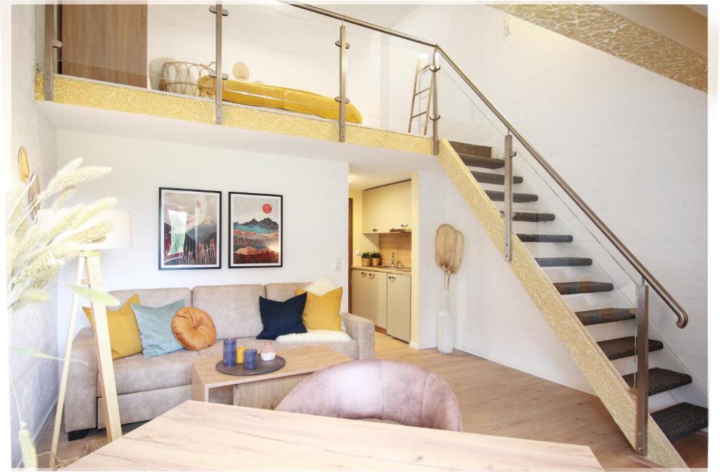 una sala de estar con una escalera en un loft en Allgäu Residenz Natur & Spa GmbH en Wiggensbach