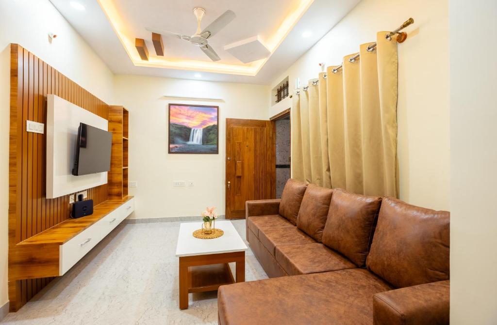 RZ Residency في بانغالور: غرفة معيشة مع أريكة وتلفزيون