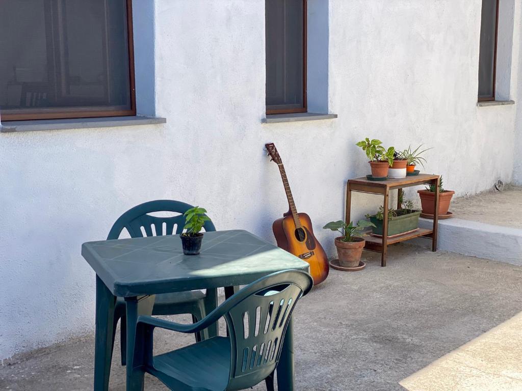 einen Tisch, einen Stuhl und eine Gitarre neben einem Tisch in der Unterkunft B&B Lichitu in Sedilo