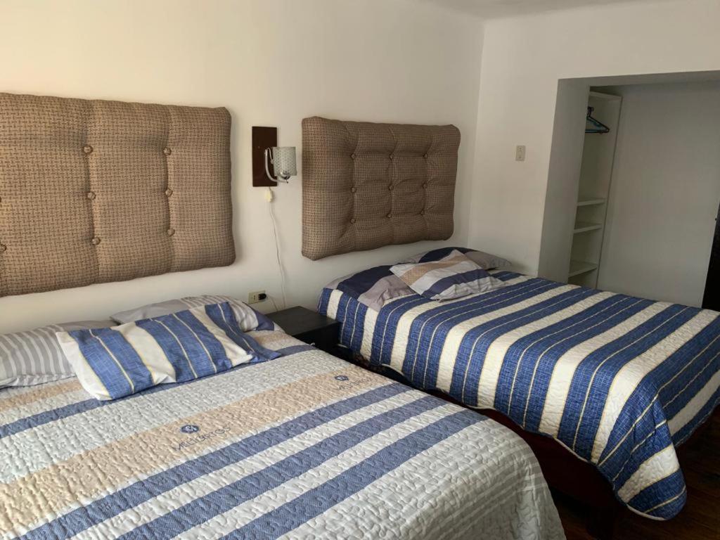 two beds sitting next to each other in a bedroom at IAN TRAVEL in Cusco