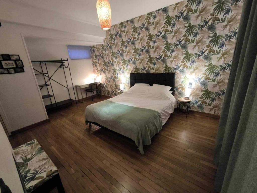 um quarto com uma cama grande e uma parede floral em ATELIER DES REVES-59620 em Aulnoye-Aymeries