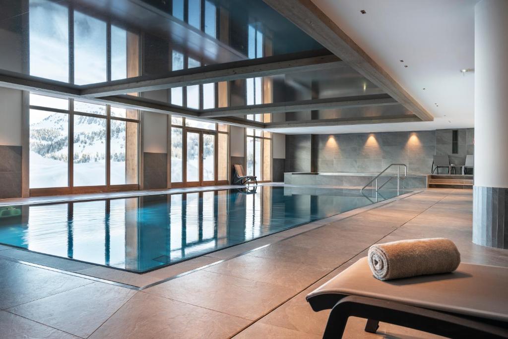 a swimming pool with a bench in a building at Résidence Manaka in Aime-La Plagne