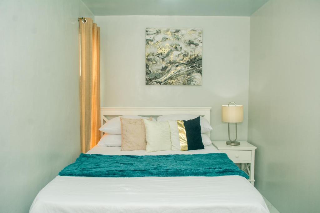 達沃市的住宿－Matina Pangi Evisa Subdivision 2 bedrooms house with parking wifi Netflix，一间卧室配有一张白色的床和蓝色的毯子
