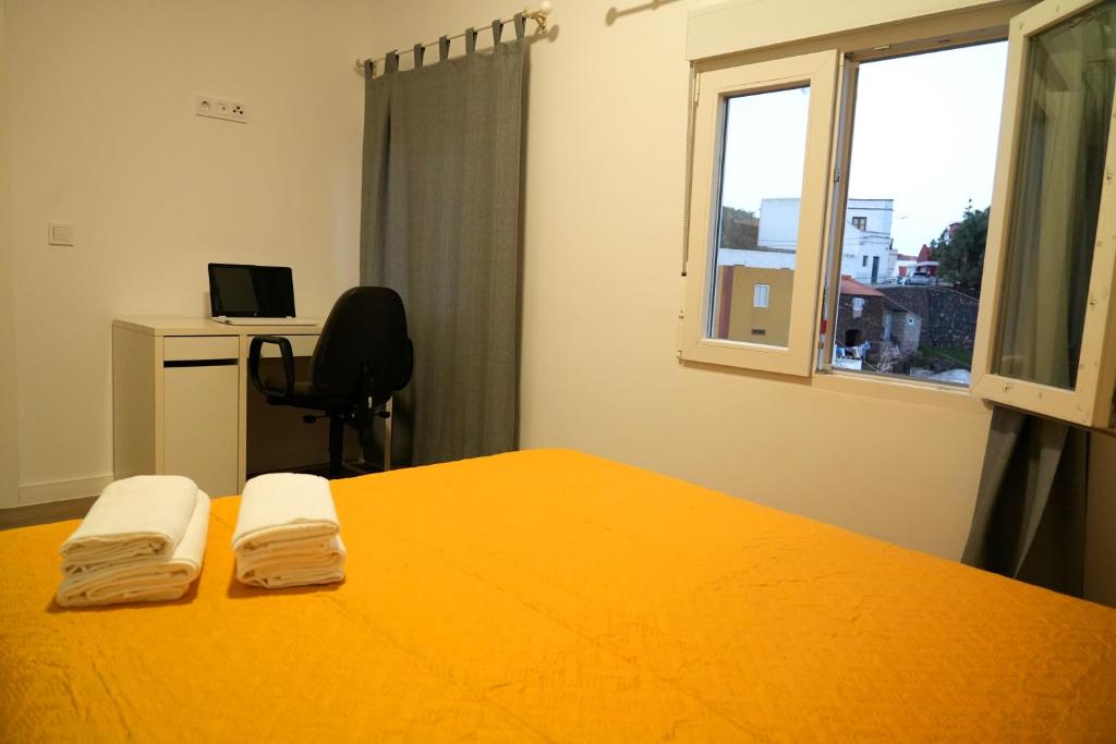 a bedroom with an orange bed and a desk and a window at Vivienda El Viajero in Valverde