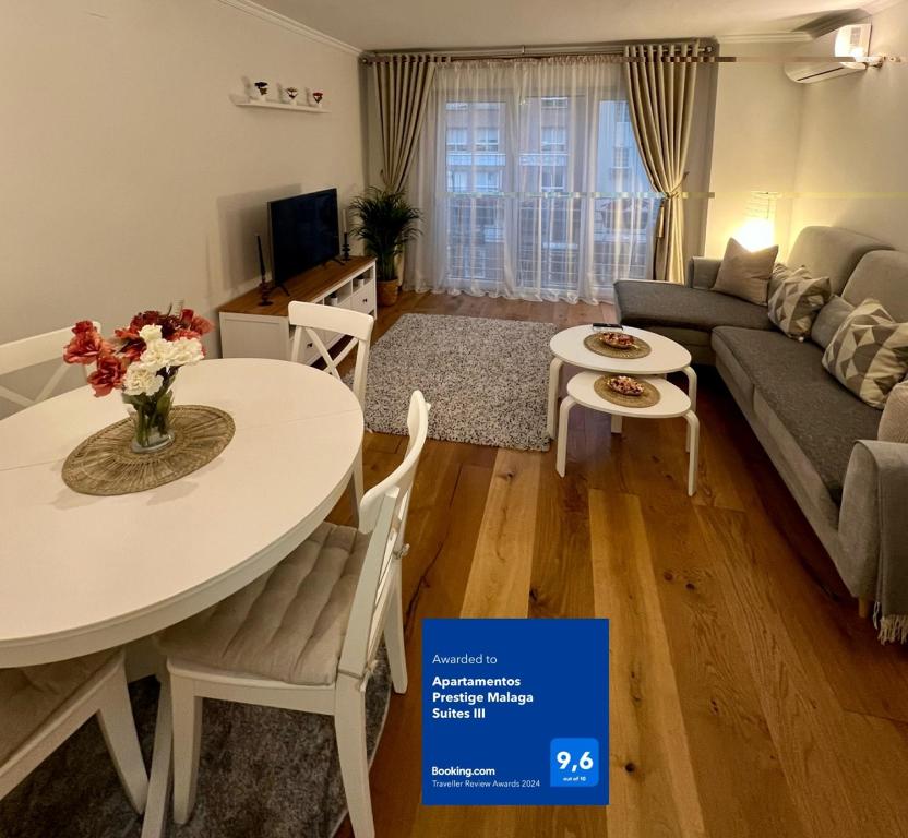 sala de estar con mesa y sofá en Apartamentos Prestige Malaga Suites III, en Málaga