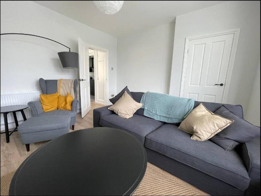 a living room with a blue couch and a table at Modern 3 bedroom home, close to City Centre and Peak District in Heeley