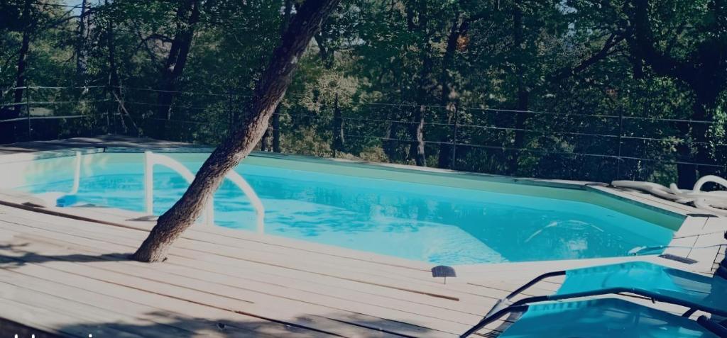 une piscine avec une terrasse en bois à côté d'un arbre dans l'établissement Villa 4P - Piscine privée sur terrain privé & clos 1400m2 - Au coeur de la Provence verte - Chien OK, à Rians