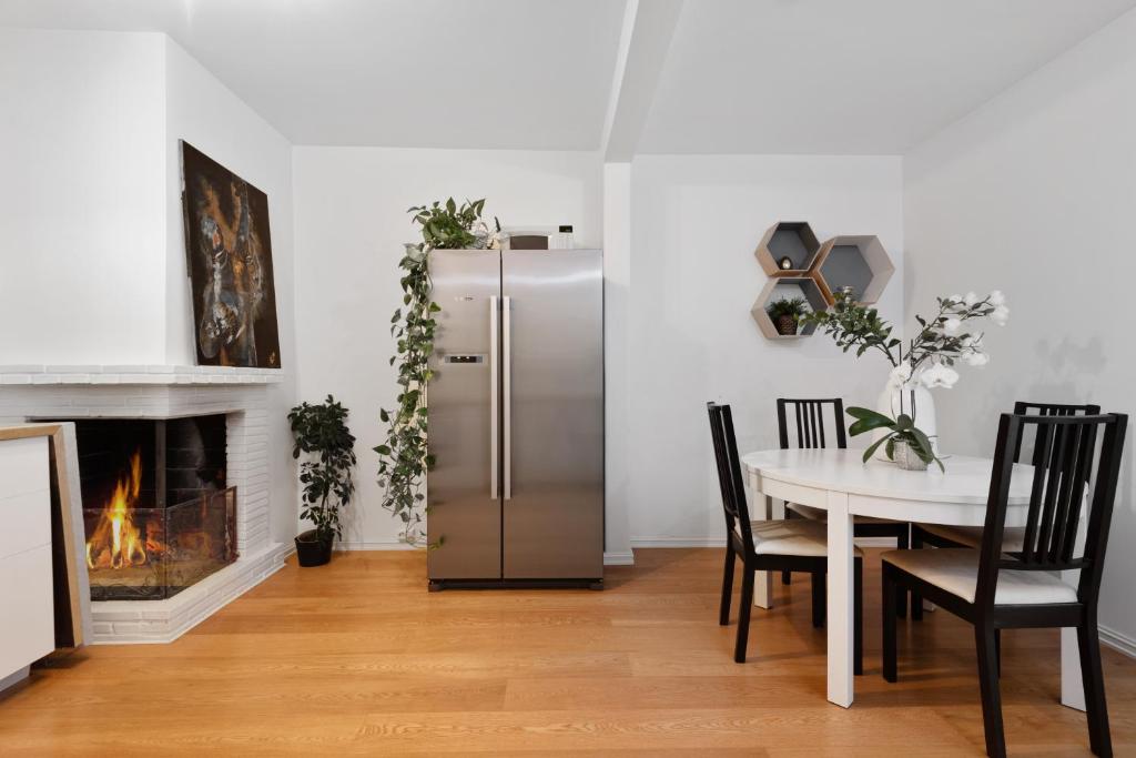 a dining room with a refrigerator and a table with a fireplace at Large apartment - Luxurious neighborhood - 8 pax in Oslo