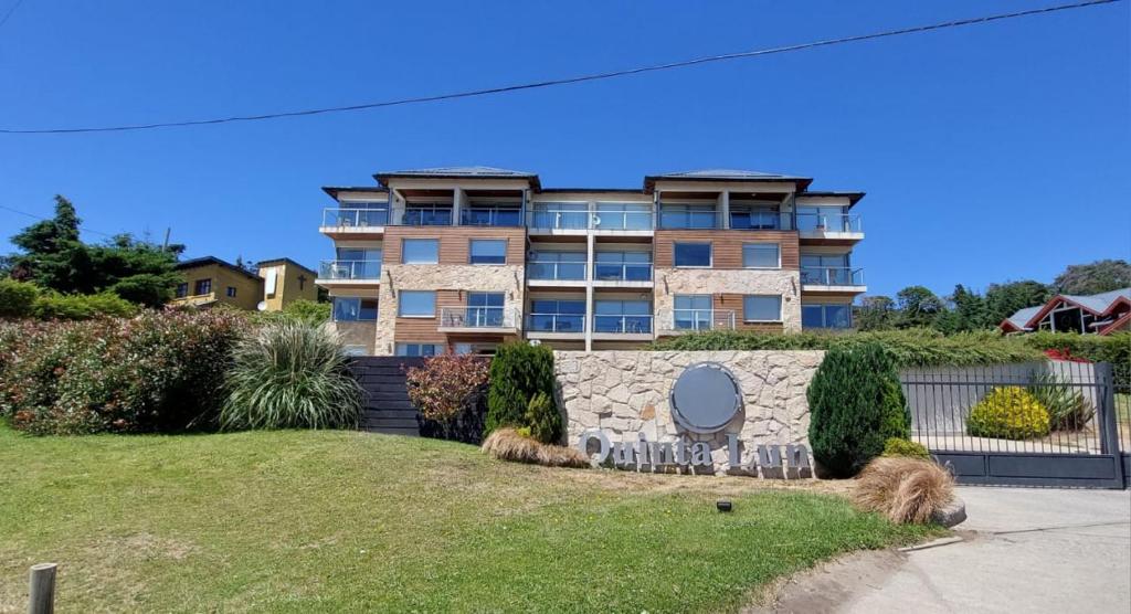 een groot appartementencomplex met een tuin ervoor bij Duplex Quinta Luna in Bariloche