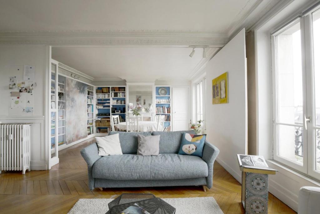 un soggiorno con divano blu in una camera di Spacious apartment with 3 bedrooms - Tour Eiffel a Parigi