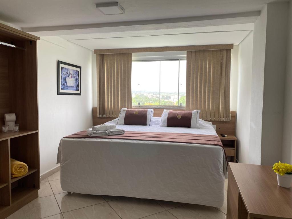 a bedroom with a large bed with a window at Hotel do Reinildo II in Cachoeira Paulista