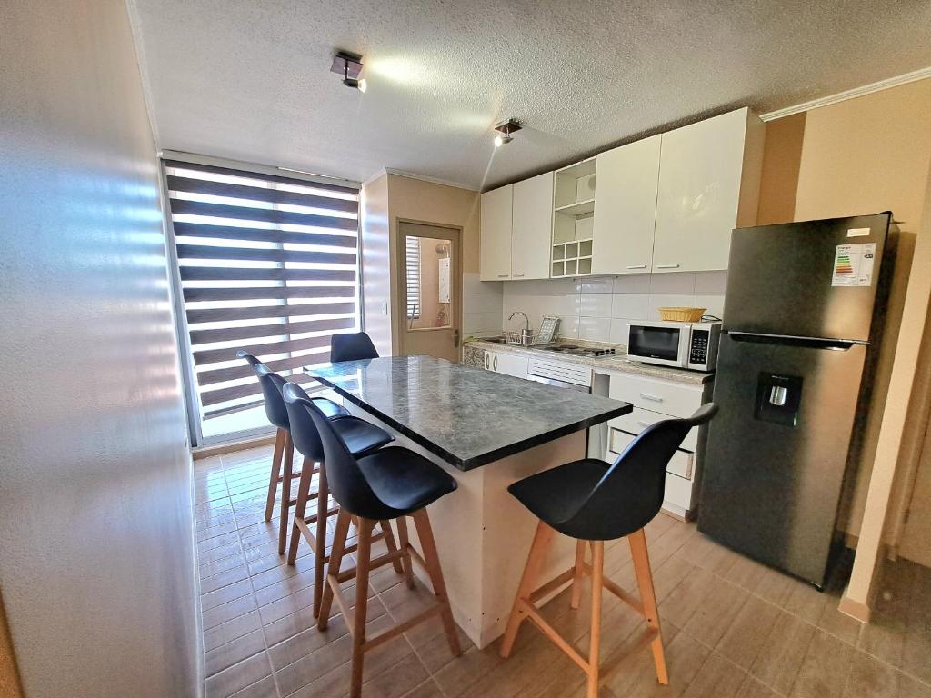 uma cozinha com uma mesa e cadeiras e um frigorífico em Departamento completo sector aeropuerto La Serena em La Serena