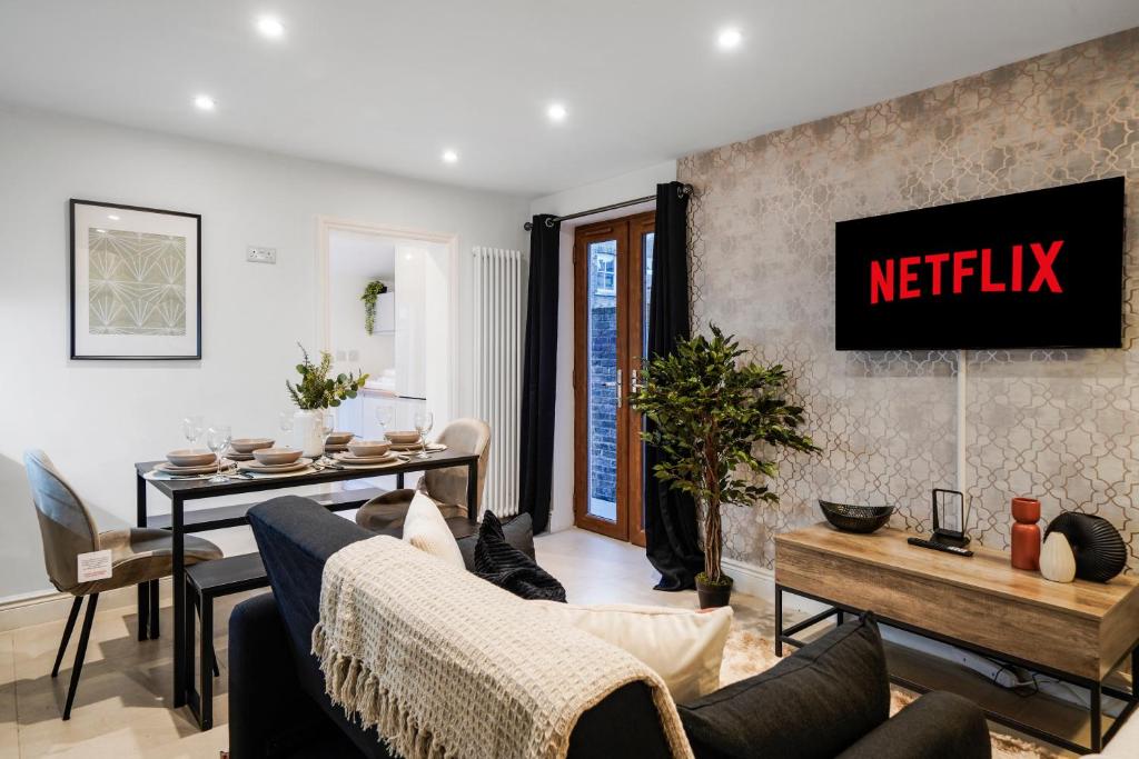 un soggiorno con un cartello di anetflix sul muro di Classy House in Maida Vale - Private Garden a Londra