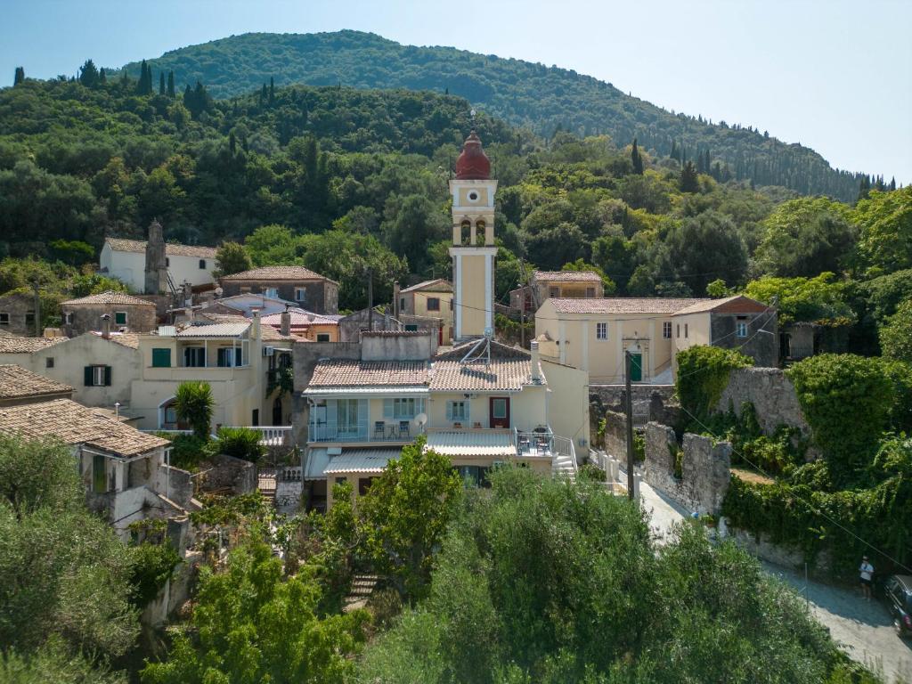 a town with a clock tower on a hill at Green Mountain Seaview Suite in Achílleion