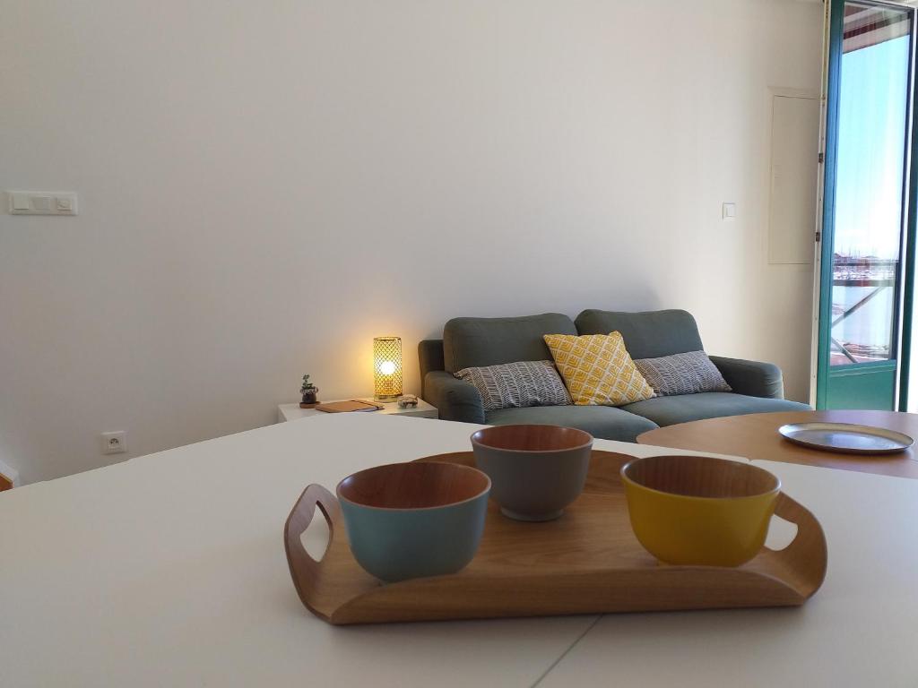 una sala de estar con 2 tazas en una bandeja de madera en Alizée en Granville