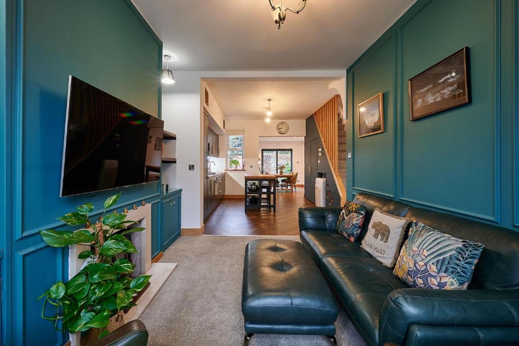 a living room with blue walls and a leather couch at Host & Stay - 19 Garswood in Liverpool