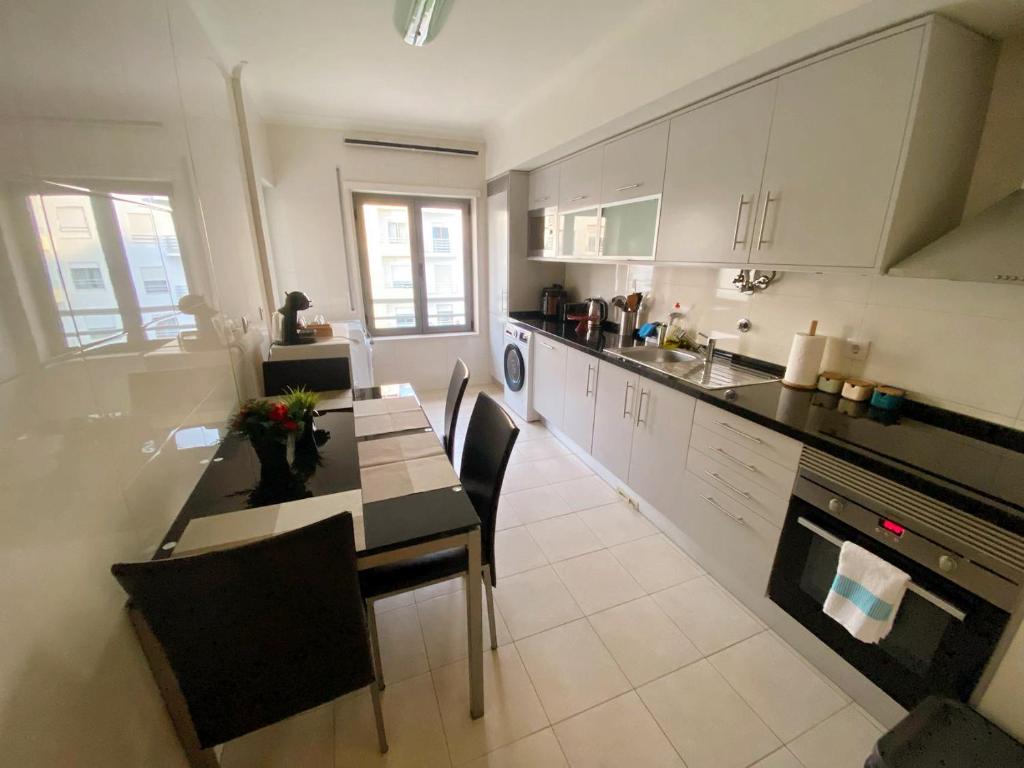 a kitchen with a table and some chairs in it at Always on the way - Road Home in Montijo, Lisbon in Montijo