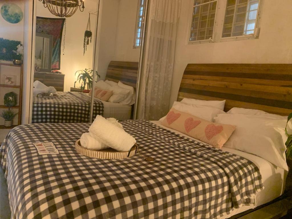 a bedroom with a bed with a checkered blanket at MI CASITA BOHO GREEN in Guayama