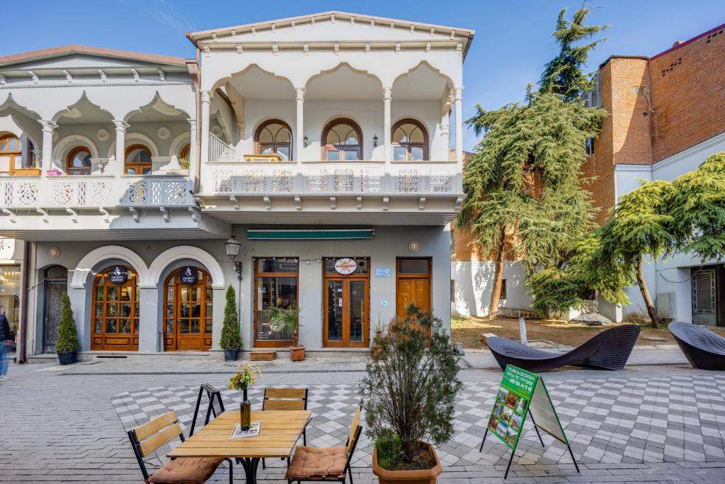 a building with a table and chairs in a courtyard at The heart of the ancient district 3BD-2BATH apartament in Tbilisi City
