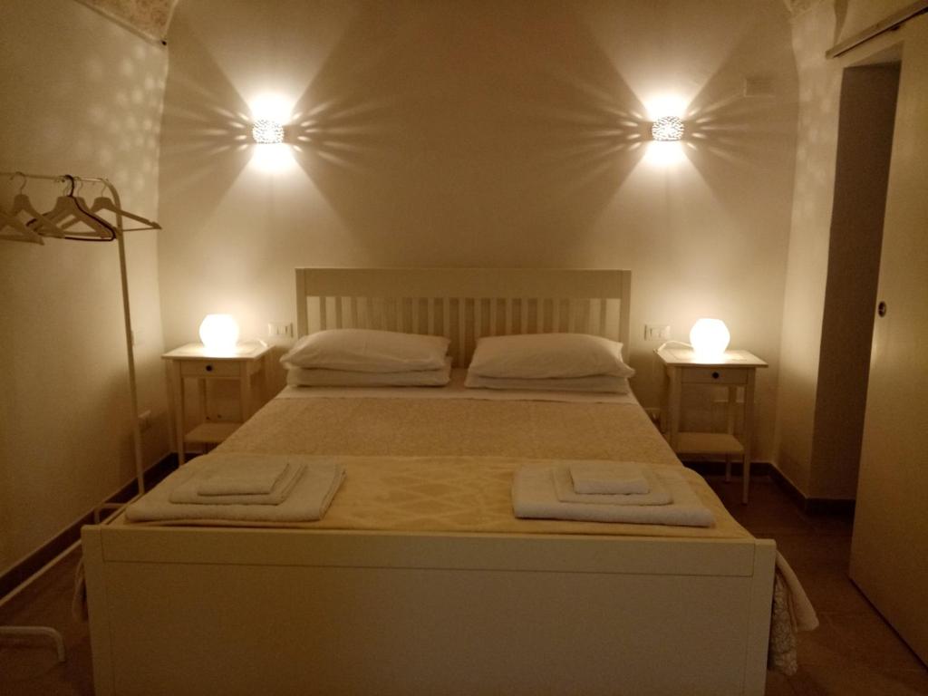 een slaapkamer met een bed met twee verlichting bij Studio Flat in White City in Ostuni