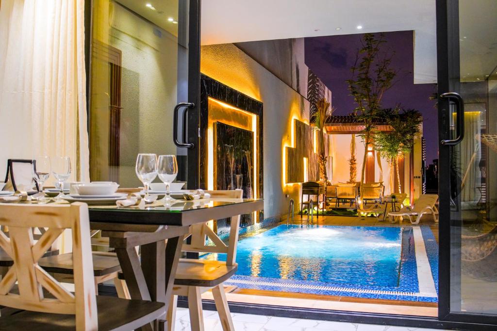 a dining area with a table and a swimming pool at The land Resort in Riyadh