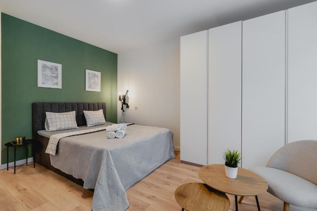 una camera con letto e parete verde di Golden Apartments Warsaw&Towarowa a Varsavia