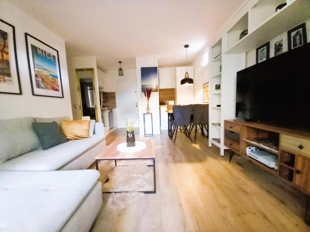 Il comprend un salon doté d'un canapé blanc et d'une télévision à écran plat. dans l'établissement Soleil de Fréjus au Lagonbleu, à Fréjus