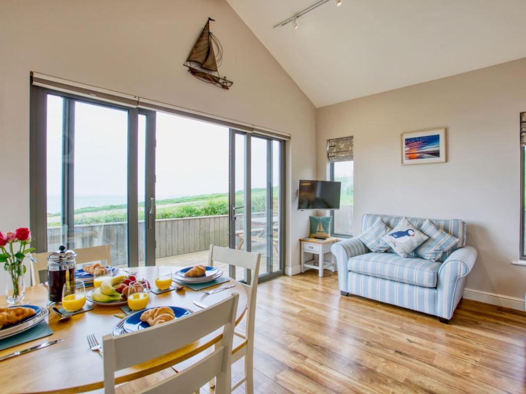 a dining room with a table and chairs and a couch at Beautiful Seaside Holiday Home in West Bay