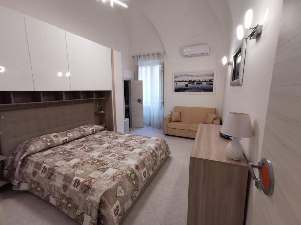 1 dormitorio con 1 cama y 1 sofá en La Pescheria Casa Vacanze, en Gaeta