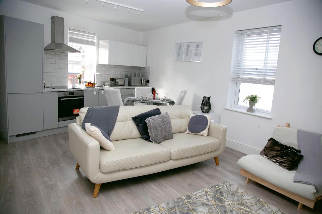 a living room with a white couch and a kitchen at Peace Home in Watford