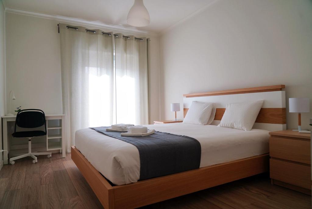 a bedroom with a large bed and a window at Always on the way - Road Home in Montijo, Lisbon in Montijo