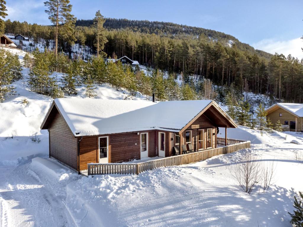 uma cabana de madeira na neve com neve em Een gezellig huis in Vrådal met adembenemend uitzicht em Vradal