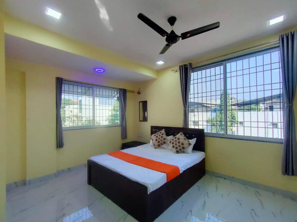 una camera con letto e ventilatore a soffitto di Vividora a Nagpur