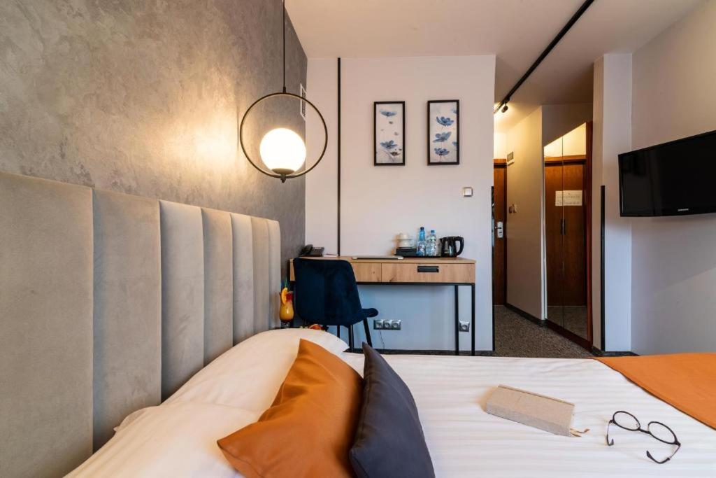 ピョートルクフ・トルィブナルスキにあるB&B HOTEL Piotrków Trybunalskiのベッドとデスクが備わるホテルルームです。