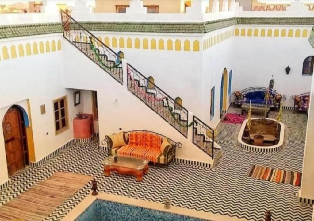 a living room with a staircase and a pool at Casa laman in Merzouga