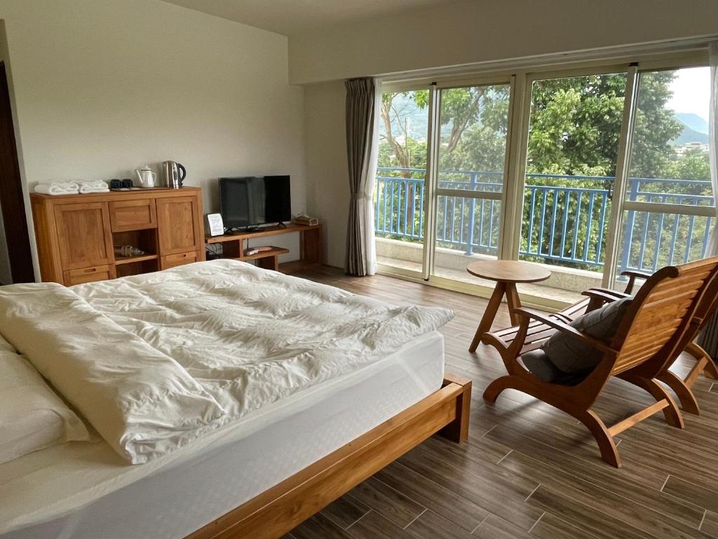- une chambre avec un grand lit et un balcon dans l'établissement 飲山風民宿, à Jian
