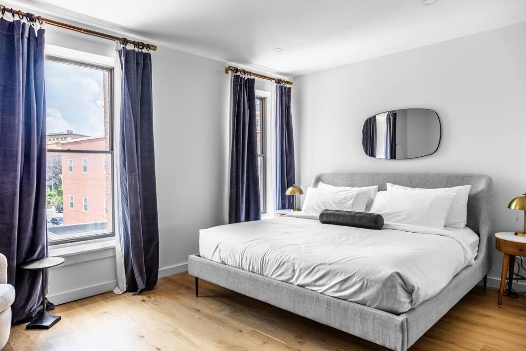 a bedroom with a bed and a large window at The Phenix Historic DTWN Hotel, King Bed, Room # 309 in Bangor
