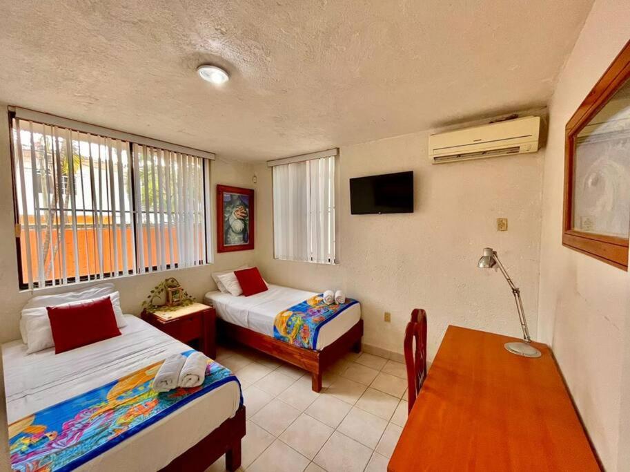 坦皮科的住宿－Villa #2, 6 recamaras en''Villas Náutico Chairel''，一间卧室配有两张床、一张桌子和一台电视。