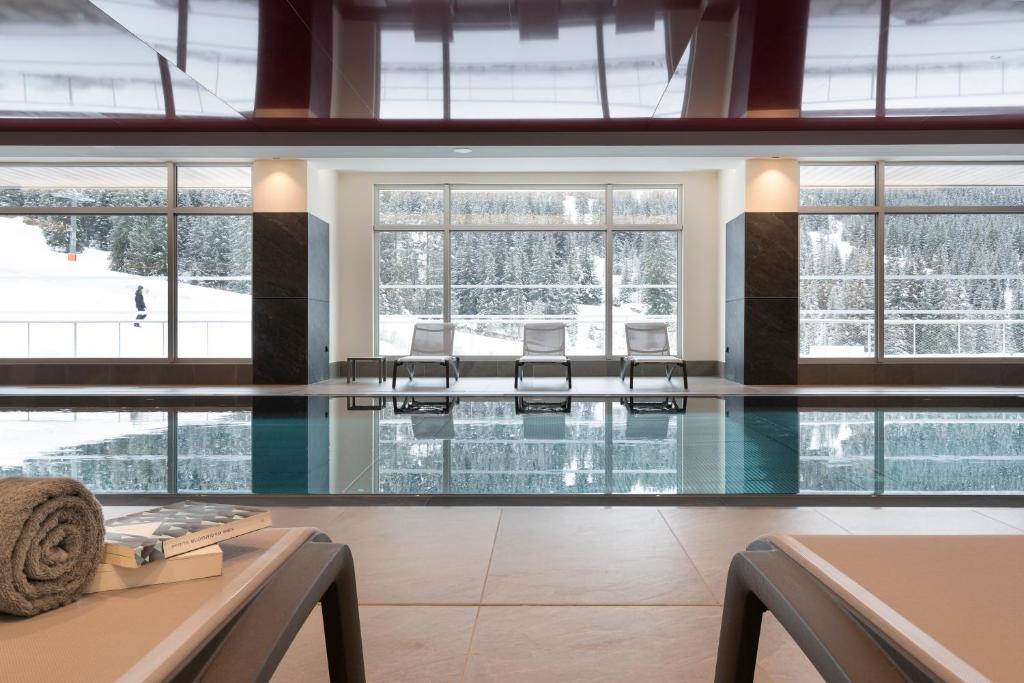 a swimming pool with chairs in a building at Résidence Alhena in Flaine